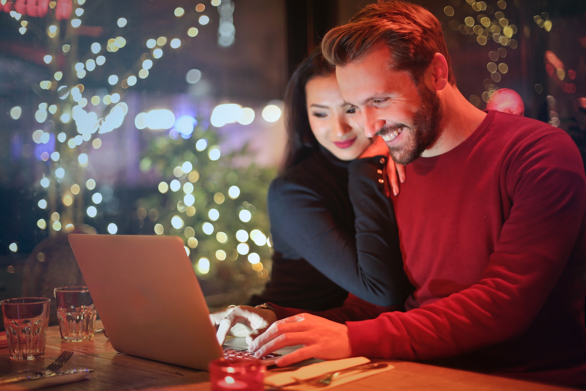 Couple qui sourit devant leur ordinateur portable