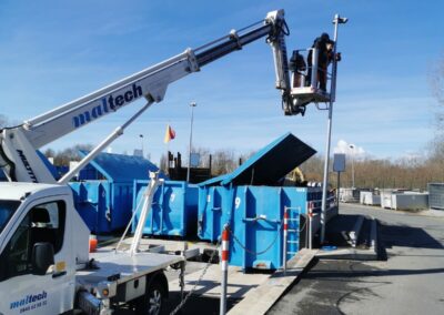 Techniciens Activ'Sécurité installant des caméras de surveillance sur un mât depuis une nacelle dans une déchetterie