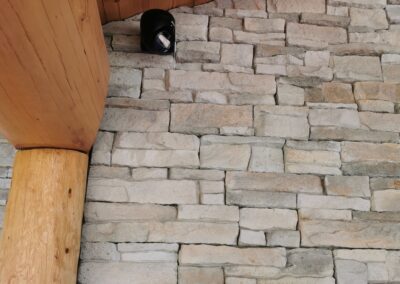 Caméra de surveillance sur chalet en madriers et mur en pierre