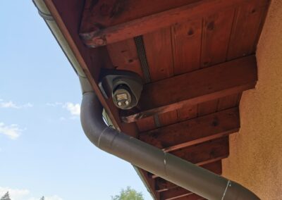 Caméra de surveillance sous l’avant-toit en bois d’une maison