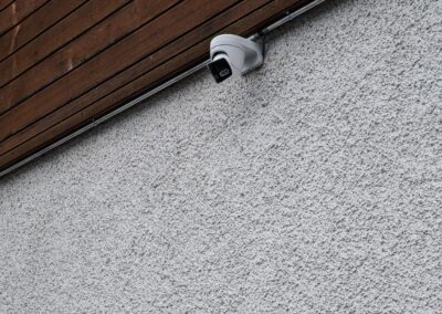 Caméra discrète sous bardage bois en façade crépie